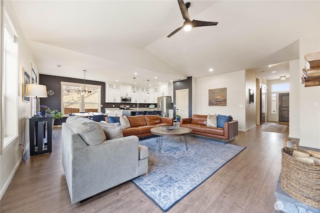 living room featuring ceiling fan with notable chandelier, wood finished floors, recessed lighting, baseboards, and vaulted ceiling