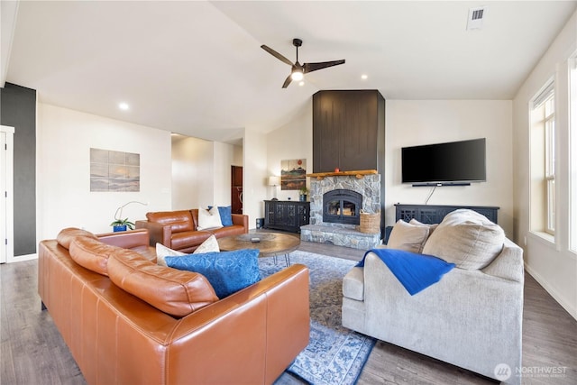 living room featuring visible vents, lofted ceiling, a fireplace, wood finished floors, and a ceiling fan