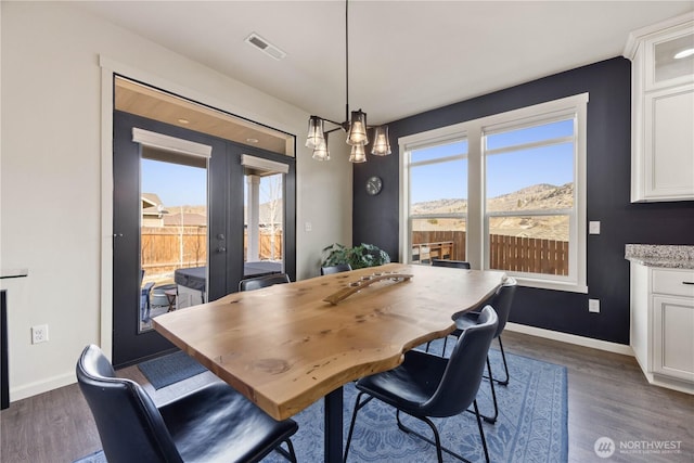 dining space featuring dark wood-style floors, french doors, visible vents, and baseboards