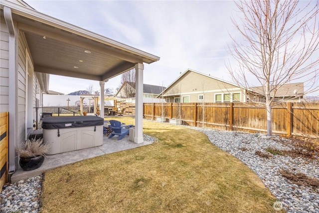 view of yard featuring a fenced backyard, a hot tub, and a patio