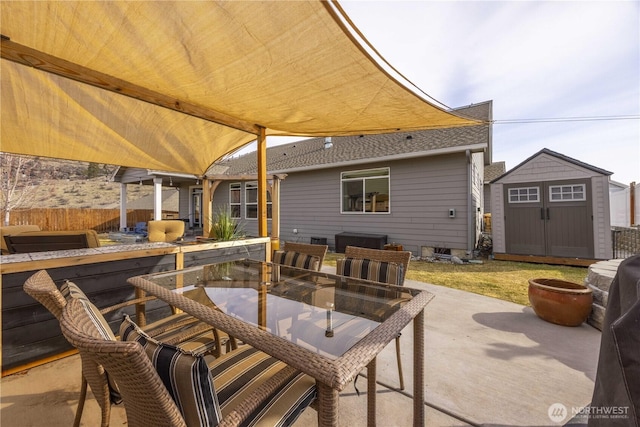 view of patio / terrace with a storage shed, outdoor dining area, an outbuilding, and fence