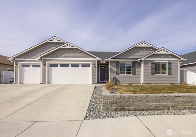 view of front facade with concrete driveway, an attached garage, fence, and a front yard