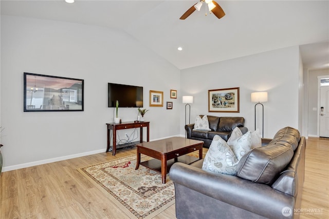 living area featuring baseboards, light wood-style flooring, and vaulted ceiling