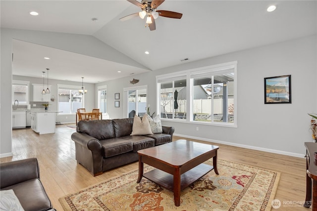 living area with visible vents, recessed lighting, light wood finished floors, baseboards, and vaulted ceiling