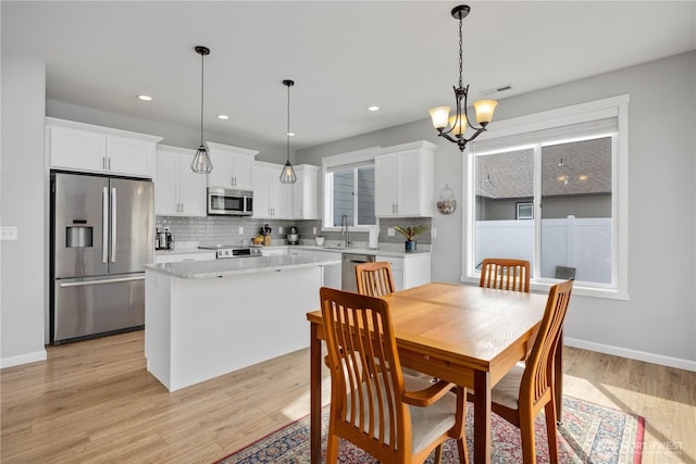 dining room featuring light wood-style flooring, recessed lighting, baseboards, and visible vents