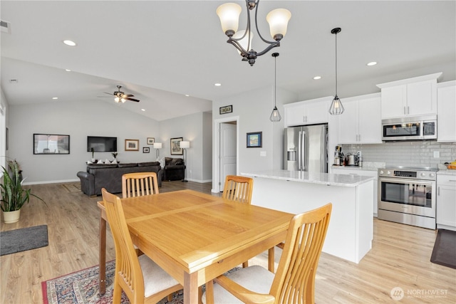 dining room featuring recessed lighting, lofted ceiling, ceiling fan with notable chandelier, and light wood finished floors