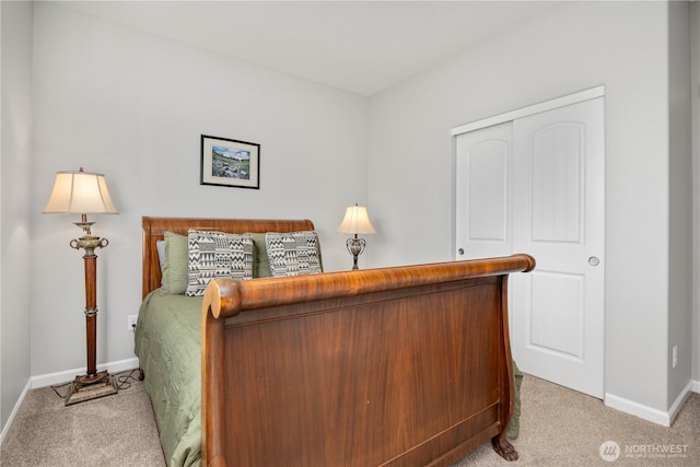 carpeted bedroom featuring a closet and baseboards