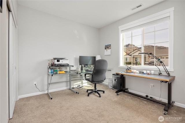 carpeted home office featuring visible vents and baseboards