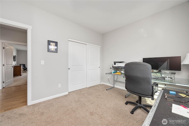 carpeted office space featuring baseboards