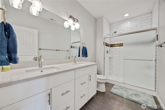 full bath with double vanity, a stall shower, and a sink