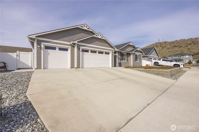 view of front of home with a gate, fence, driveway, and an attached garage