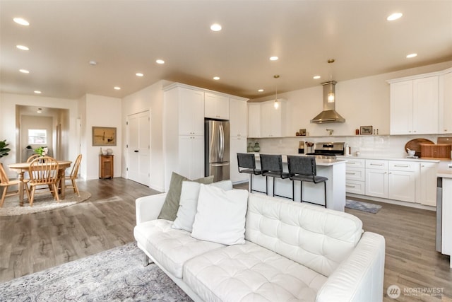 living room with recessed lighting and wood finished floors