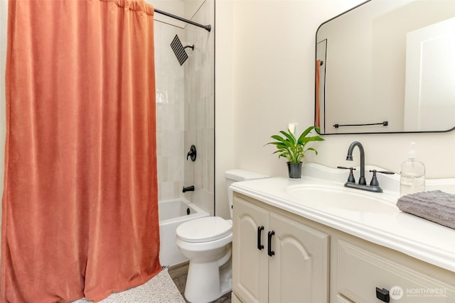 bathroom featuring shower / bath combo with shower curtain, toilet, and vanity