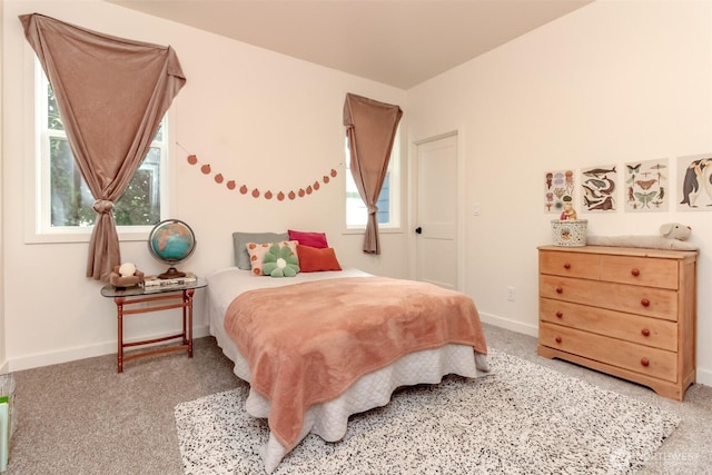 bedroom featuring light colored carpet and baseboards