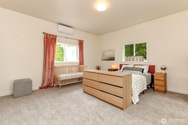 bedroom featuring a wall unit AC, baseboards, and light carpet