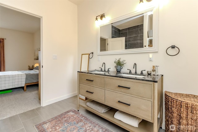 ensuite bathroom with a sink, baseboards, ensuite bathroom, and double vanity