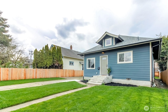 bungalow-style home with a front lawn and fence