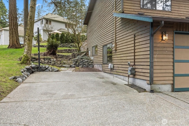 view of side of home featuring a patio area, an attached garage, and a yard