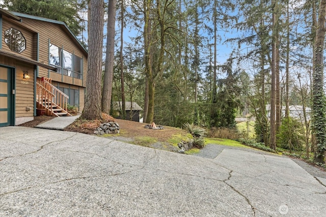 view of yard featuring stairway and driveway