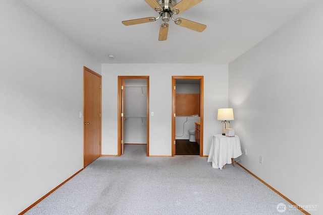 unfurnished bedroom with ensuite bath, a closet, carpet, baseboards, and a spacious closet