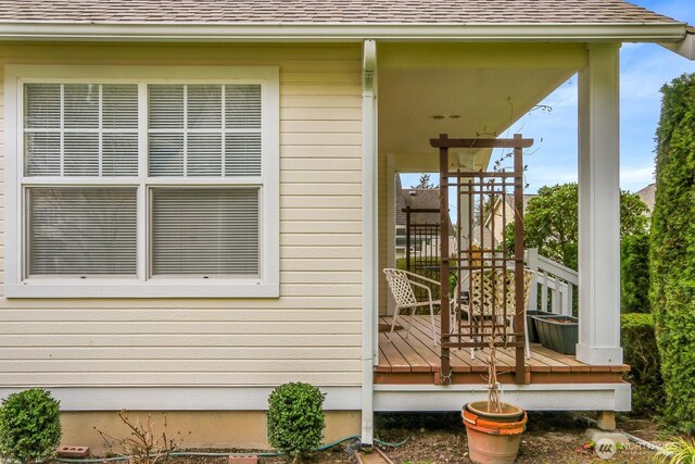 exterior space with a wooden deck and roof with shingles