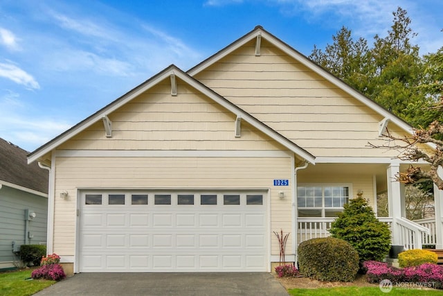 view of front of house featuring concrete driveway, an attached garage, and covered porch