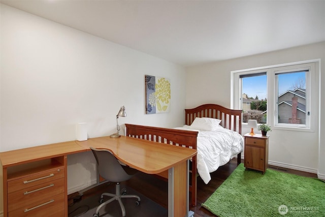 bedroom featuring wood finished floors and baseboards