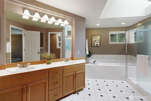 full bath featuring a garden tub, double vanity, a stall shower, and a sink