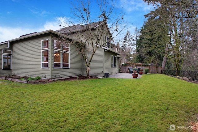 rear view of house with fence, crawl space, central air condition unit, a patio area, and a lawn