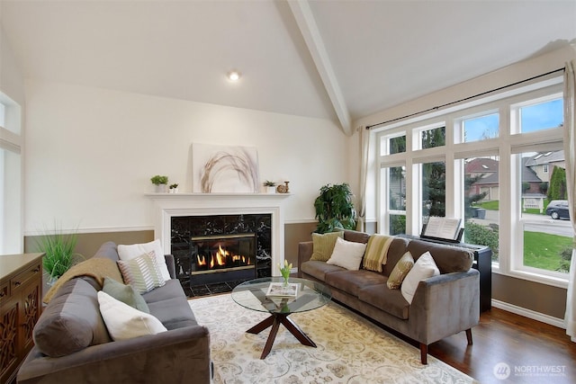 living area with wood finished floors, vaulted ceiling with beams, baseboards, and a premium fireplace