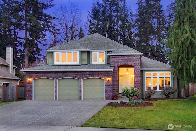 view of front facade featuring fence, roof with shingles, concrete driveway, a front yard, and brick siding