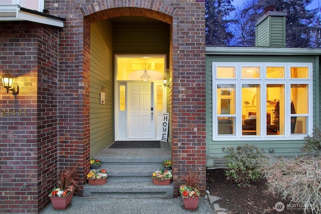 entrance to property featuring brick siding