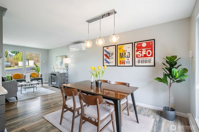 dining area with baseboards, wood finished floors, and a wall unit AC