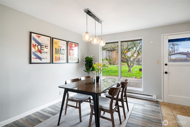 dining area with a baseboard radiator, baseboards, and wood finished floors