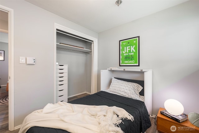 bedroom featuring a closet, baseboards, and wood finished floors