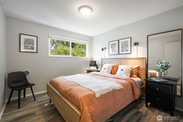 bedroom with dark wood finished floors and baseboards