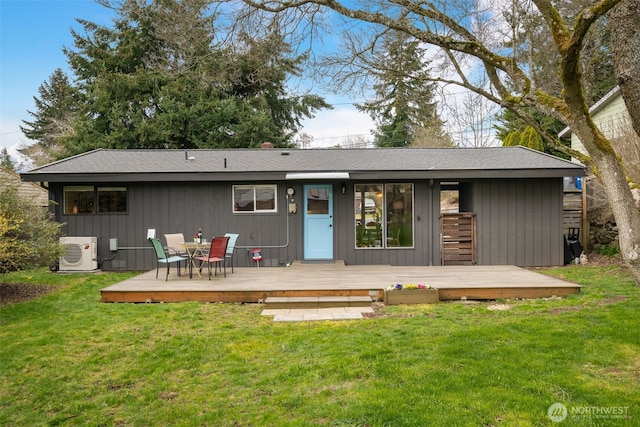 back of house with a deck, ac unit, and a lawn