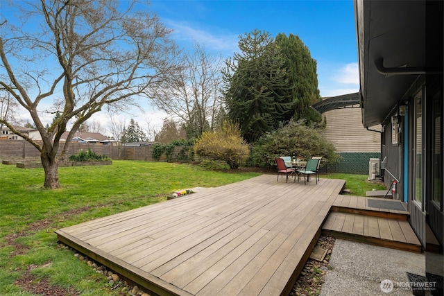 deck with a lawn and a fenced backyard