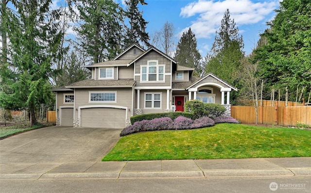 craftsman house featuring an attached garage, driveway, a front yard, and fence