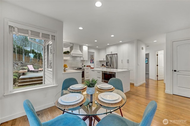 dining room with recessed lighting, light wood-type flooring, and baseboards