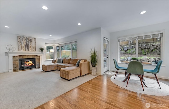 living room featuring recessed lighting, baseboards, wood finished floors, and a tile fireplace