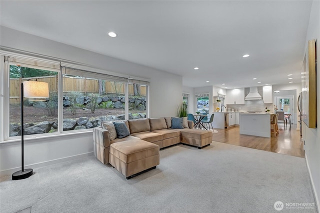 living room with recessed lighting, baseboards, and light carpet