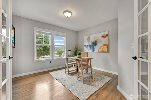 dining area with baseboards and wood finished floors