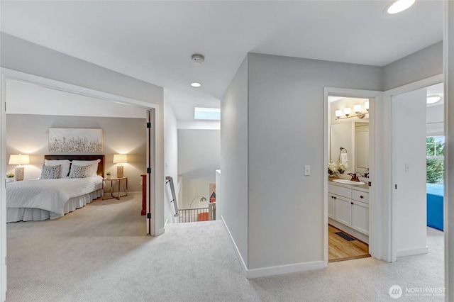 bedroom with visible vents, a sink, recessed lighting, baseboards, and light colored carpet