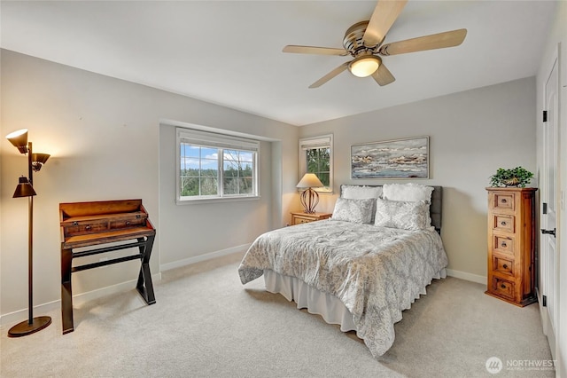 bedroom featuring light colored carpet, a ceiling fan, and baseboards