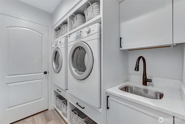 washroom featuring a sink, cabinet space, and washer and clothes dryer