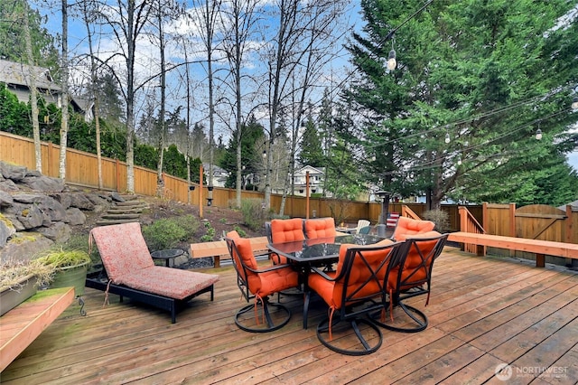 deck with a fenced backyard and outdoor dining space