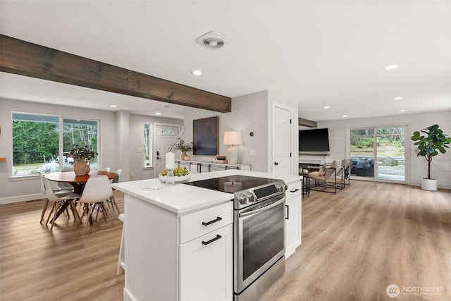 kitchen featuring recessed lighting, stainless steel electric range, light countertops, white cabinetry, and light wood-type flooring