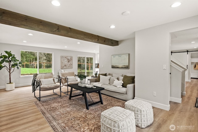 living area with light wood-type flooring, a barn door, beamed ceiling, and recessed lighting