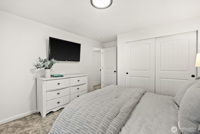 bedroom featuring a closet, baseboards, and light colored carpet